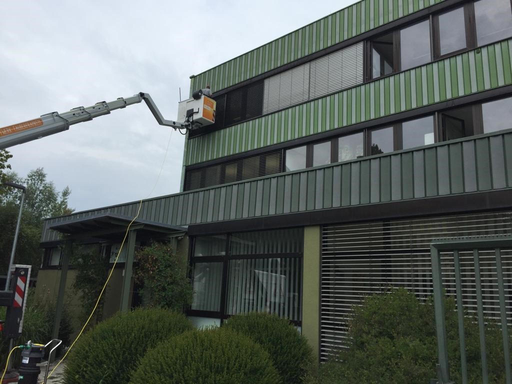 Reinigung der Fensterfront eines Firmengebäudes.